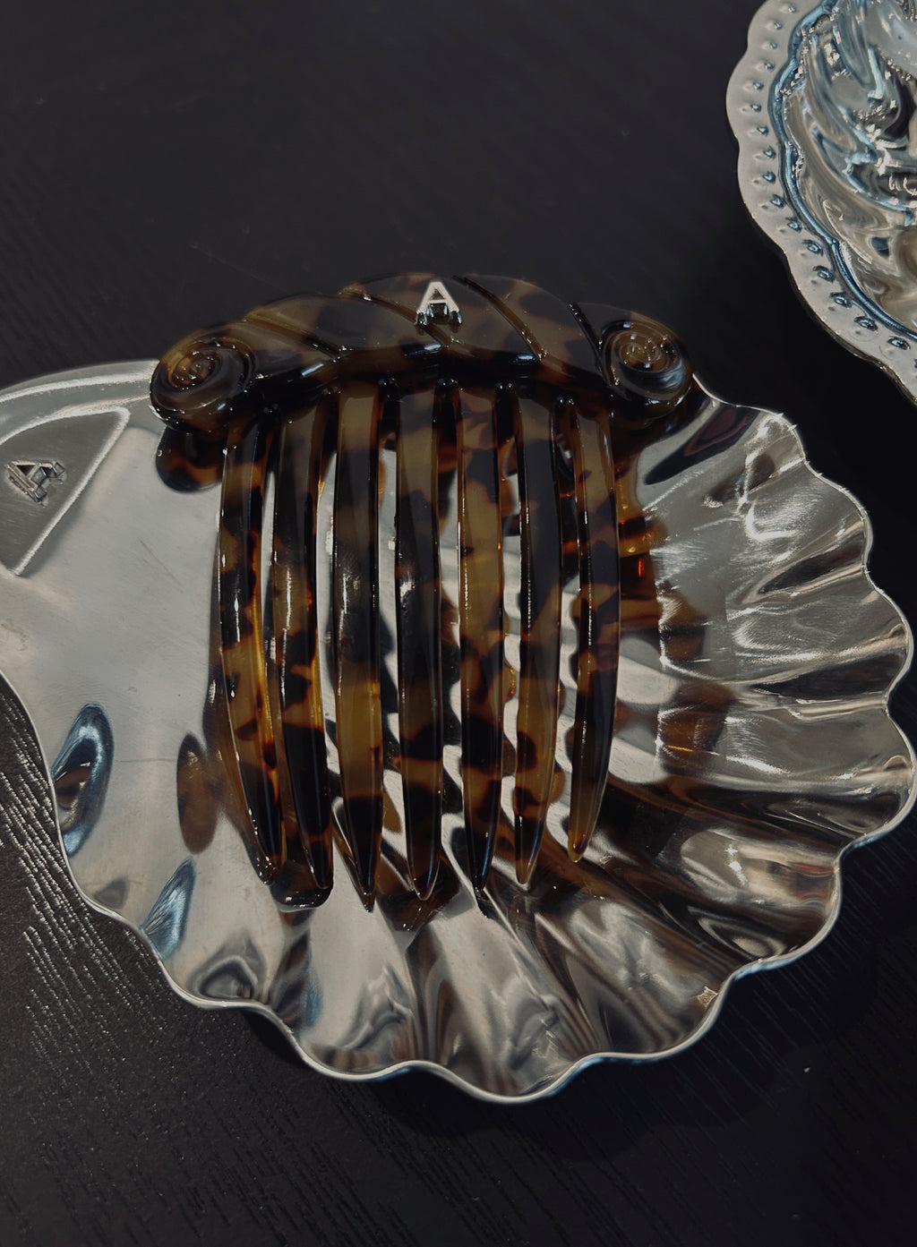 Tortoiseshell hair comb on a decorative silver dish