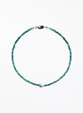 Turquoise beaded necklace with a pearl pendant on a white background