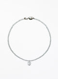 A delicate beaded necklace with a small faceted clear crystal pendant, displayed on a clean white background.