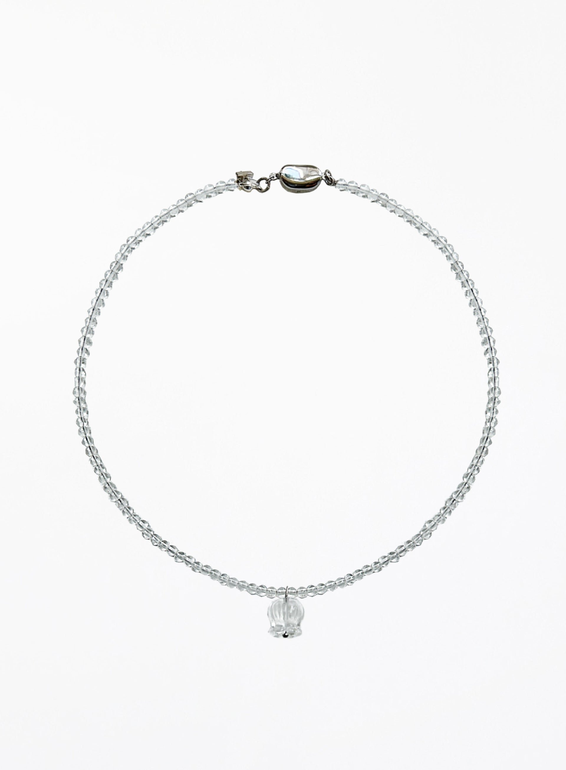 A delicate beaded necklace with a small faceted clear crystal pendant, displayed on a clean white background.