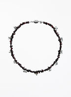 Necklace with red beads and silver accents on a white background