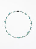 A delicate beaded necklace featuring light blue and white beads with small, irregular light blue stone accents, displayed on a clean white background.