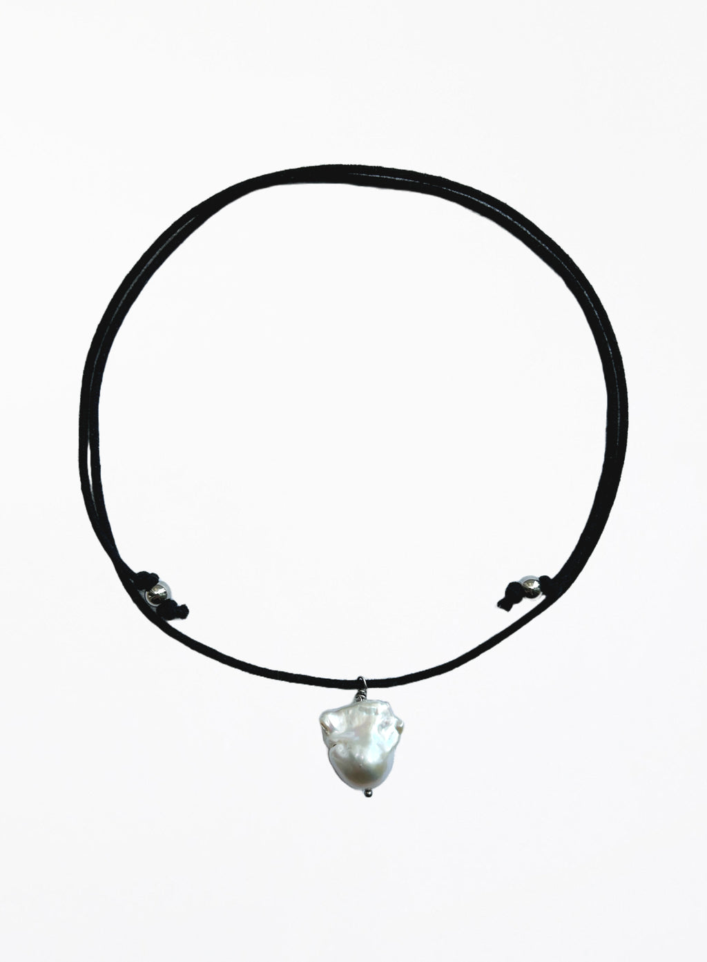 black cord necklace with baroque pearl in the center against white background