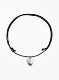 black cord necklace with baroque pearl in the center against white background