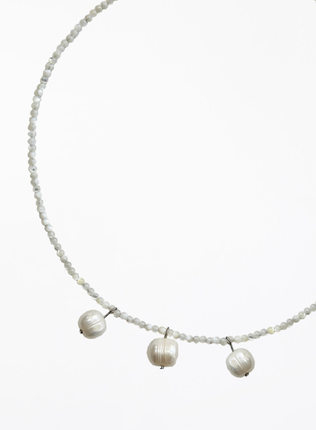 Necklace with three cultured pearl beads on a white background