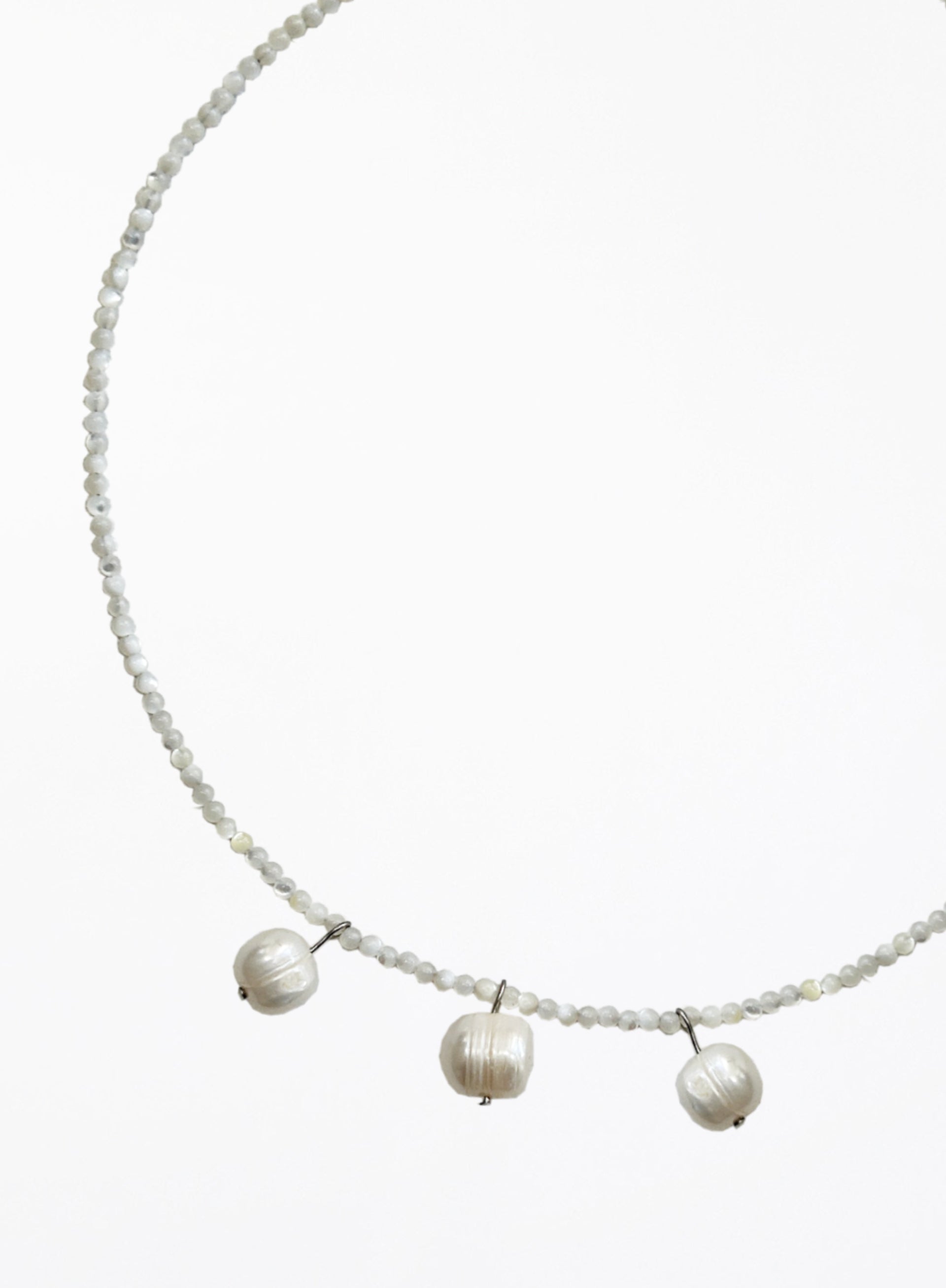 Necklace with three cultured pearl beads on a white background