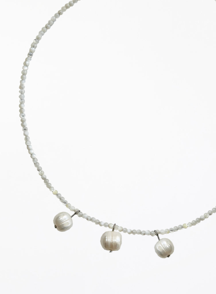 Necklace with three cultured pearl beads on a white background