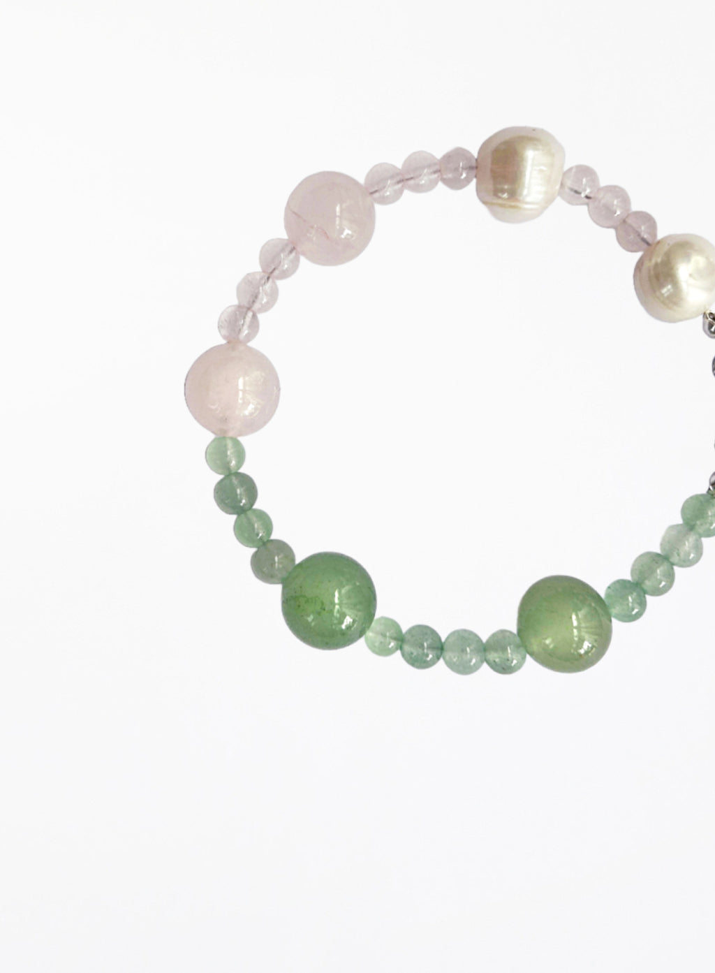 Beaded bracelet with pearls and green pink  stones on a white background