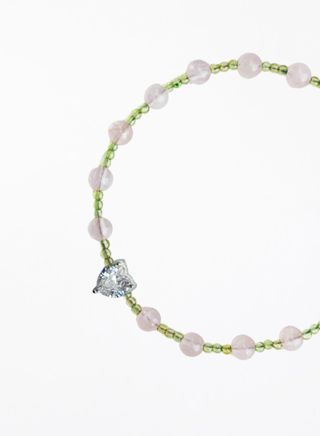 bracelet with pink beads and a heart-shaped charm on a white background