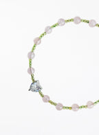 bracelet with pink beads and a heart-shaped charm on a white background