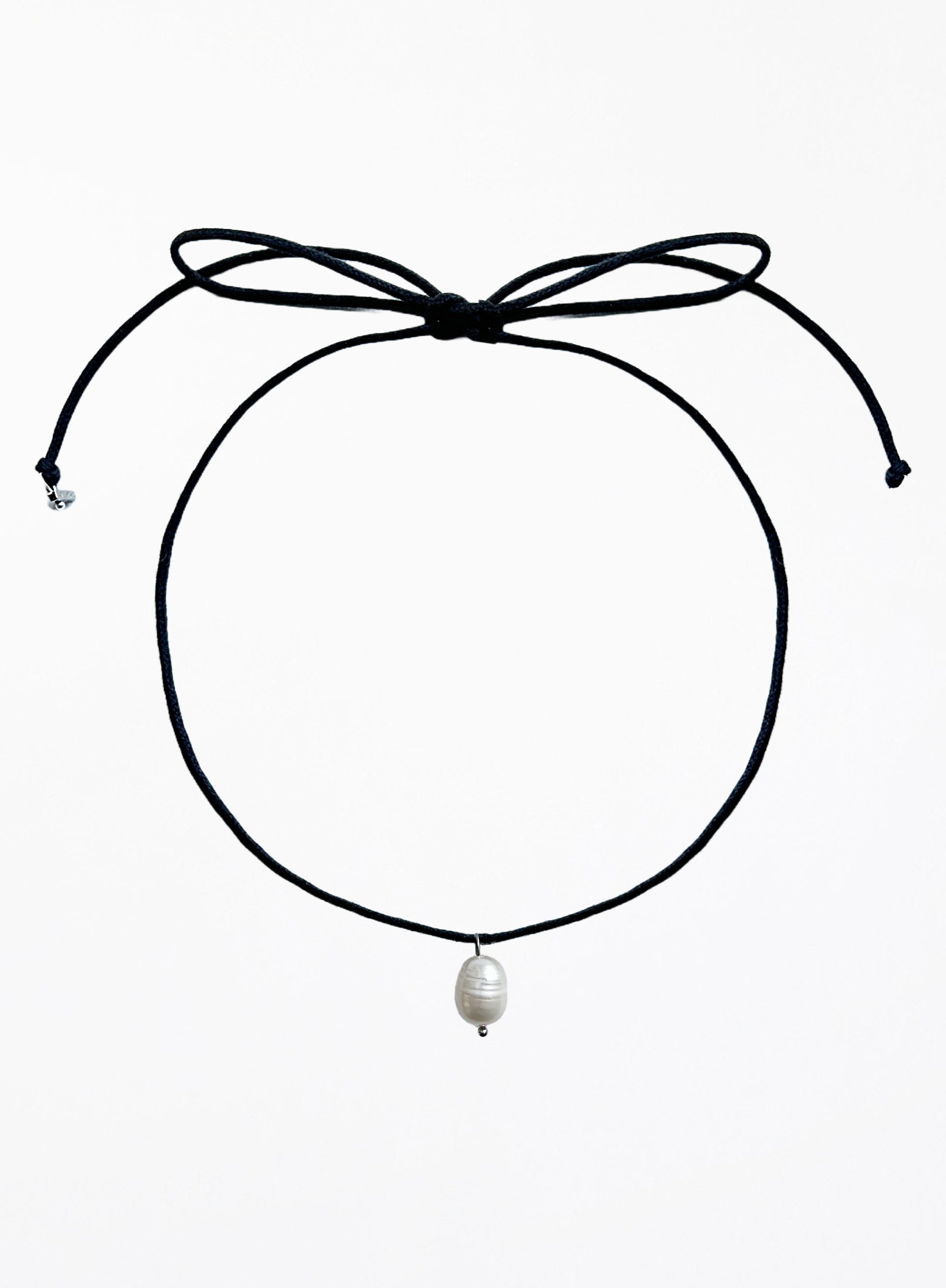 Black choker necklace with a pearl pendant on a white background