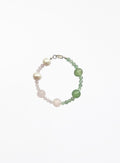 Beaded bracelet with pearls and green pink  stones on a white background