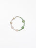 Beaded bracelet with pearls and green pink  stones on a white background