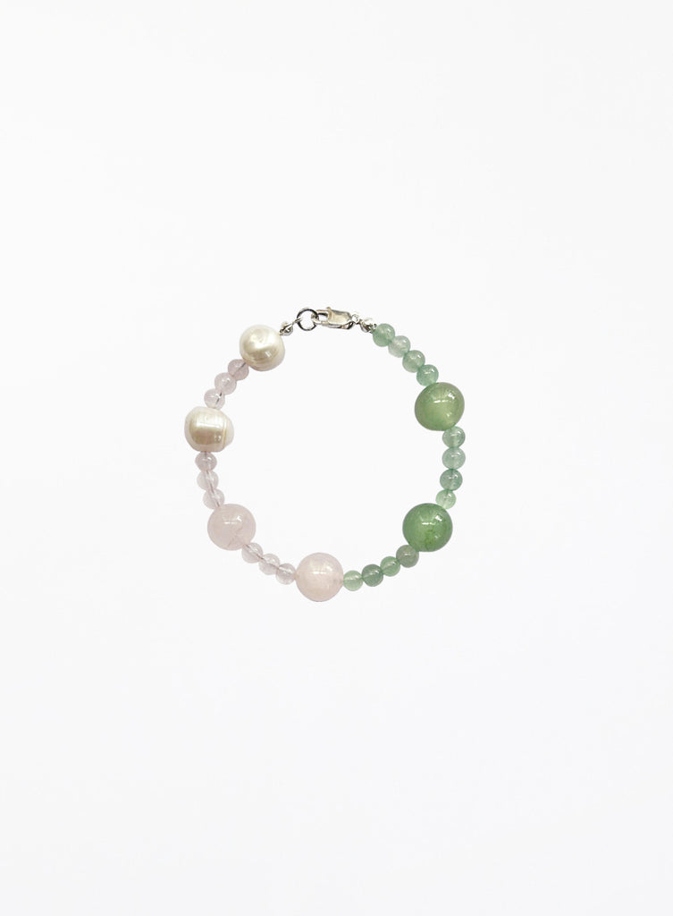 Beaded bracelet with pearls and green pink  stones on a white background