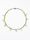 Necklace with green beads and white beaded charms on a white background