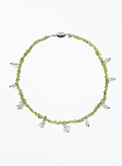 Necklace with green beads and white beaded charms on a white background