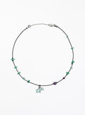 Necklace with green beads and a small charm on a white background