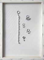 flatlay of multiple pearl earrings on a wooden frame