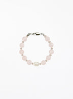 Bracelet with rose quartz beads and solo pearl on a white background