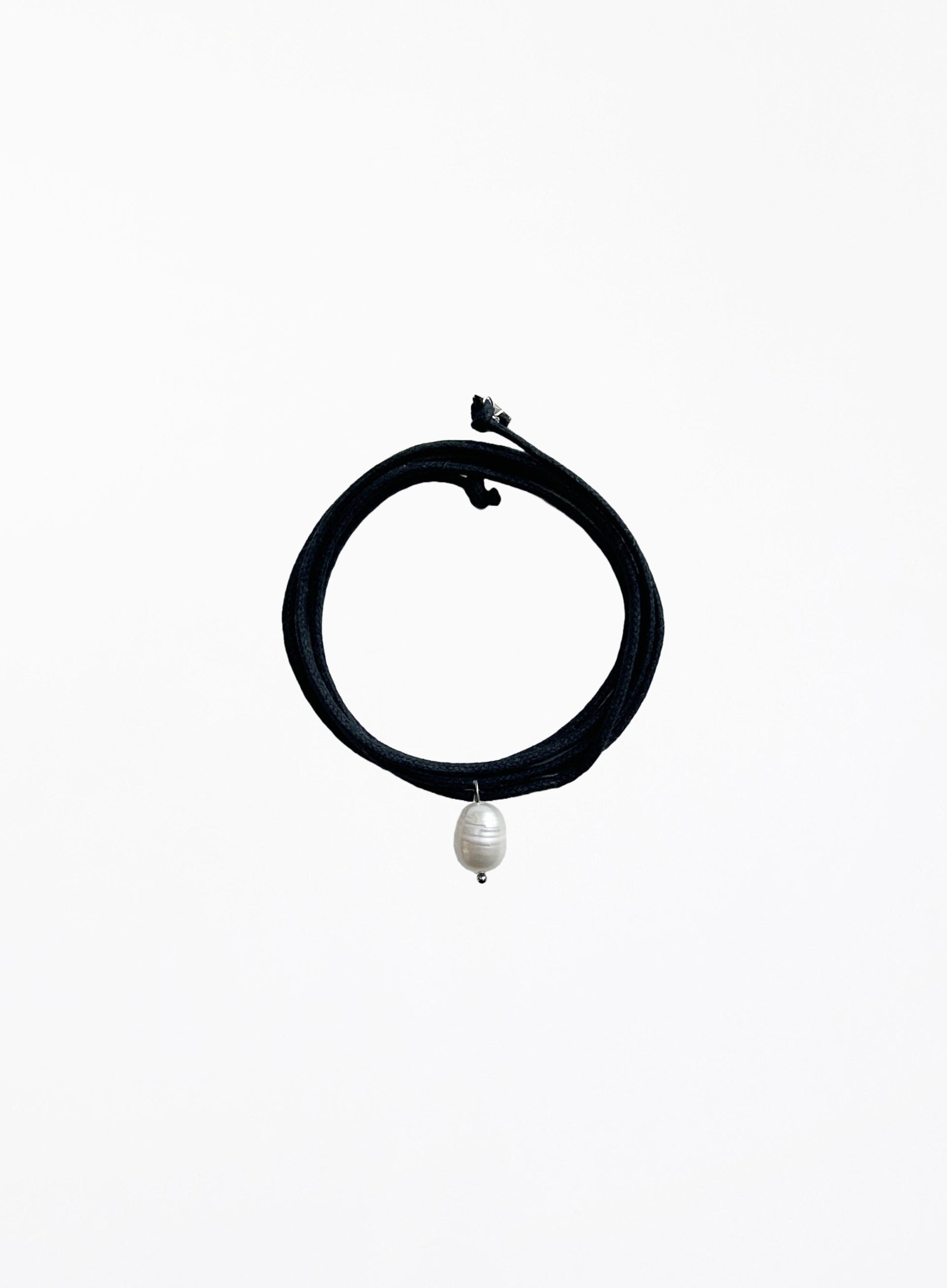 Black choker necklace with a pearl pendant on a white background