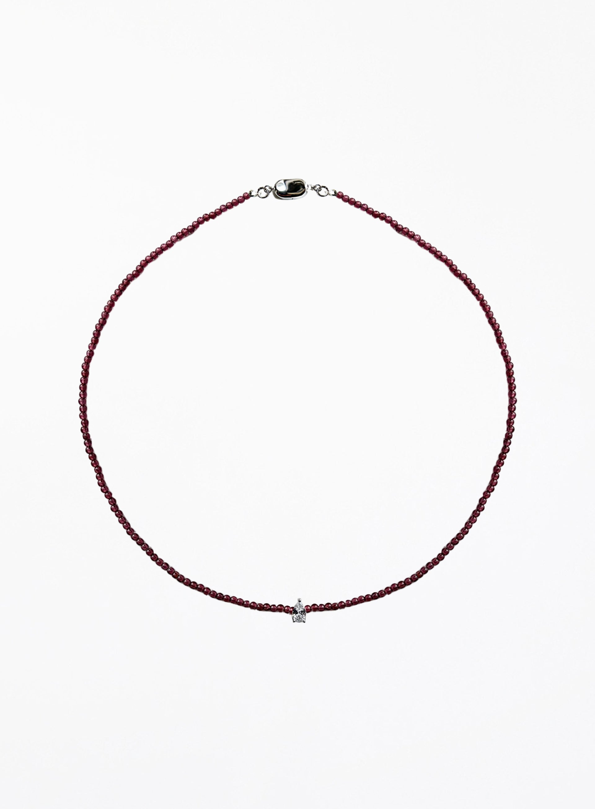 Thin garnet beaded necklace with tear drop charm on a white background