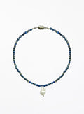 Necklace with blue beads and a white baroque pearl pendant on a white background