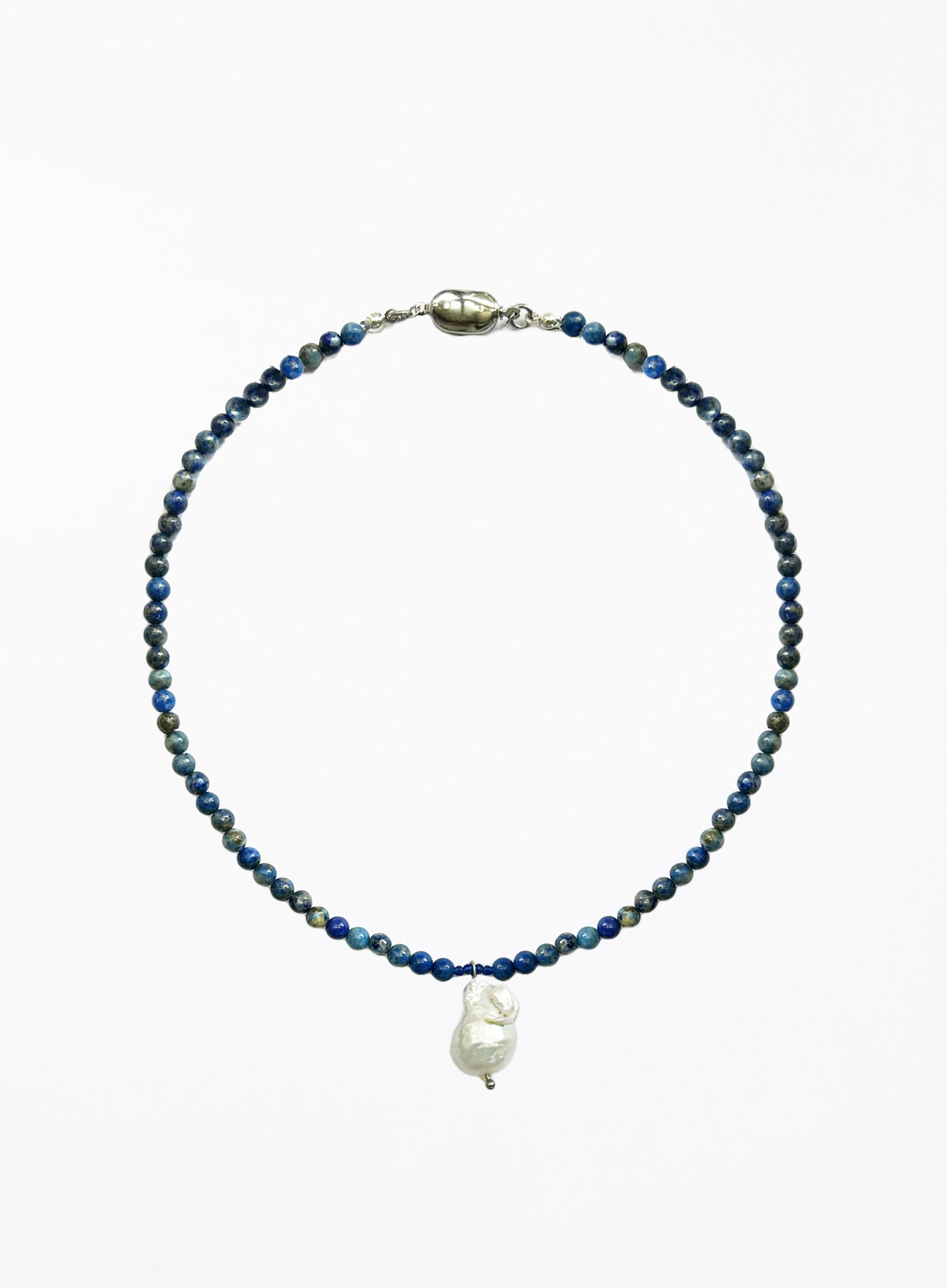 Necklace with blue beads and a white baroque pearl pendant on a white background