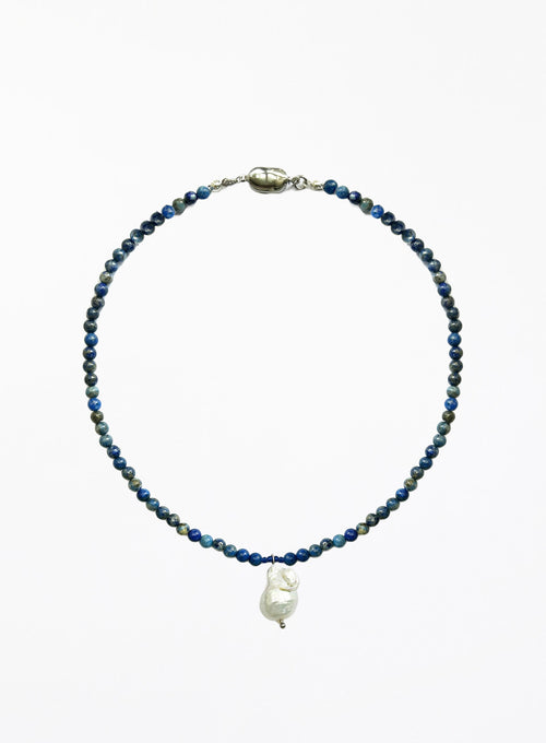 Necklace with blue beads and a white baroque pearl pendant on a white background