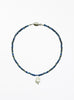 Necklace with blue beads and a white baroque pearl pendant on a white background