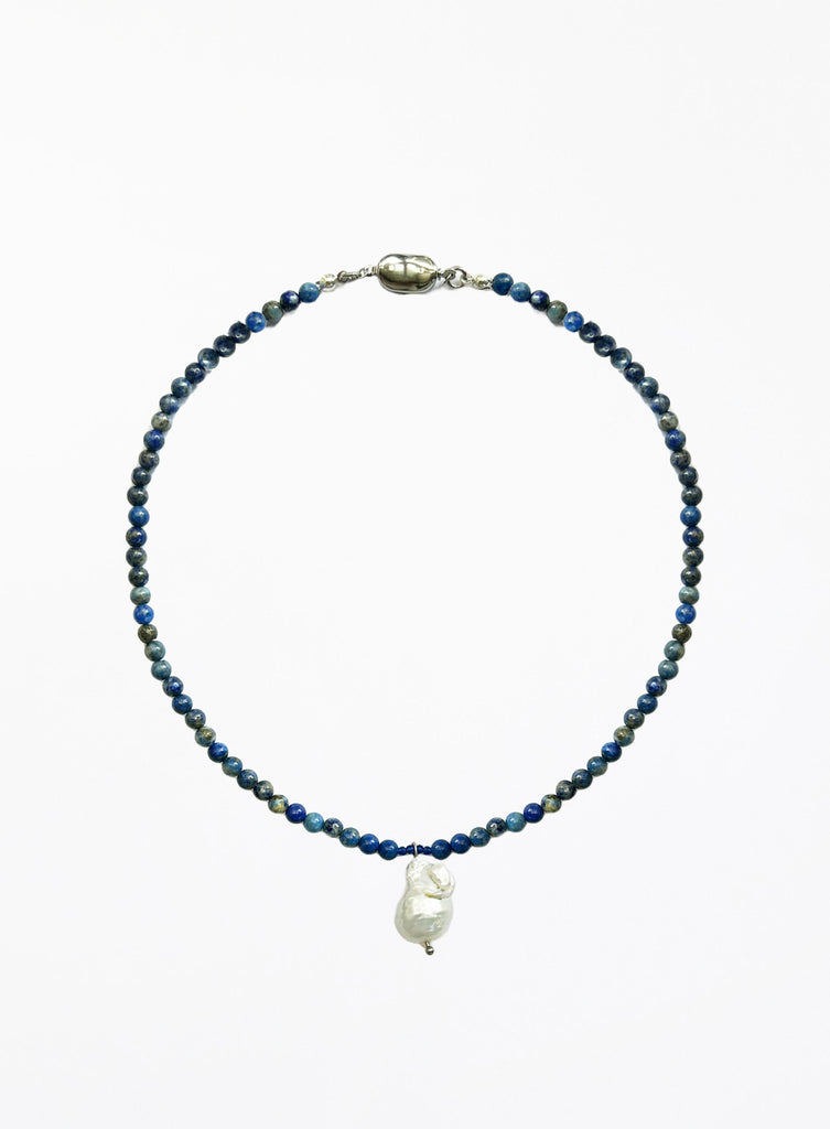 Necklace with blue beads and a white baroque pearl pendant on a white background