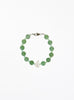 Green beaded bracelet with pearl on a white background