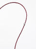 Thin garnet beaded necklace with tear drop charm on a white background