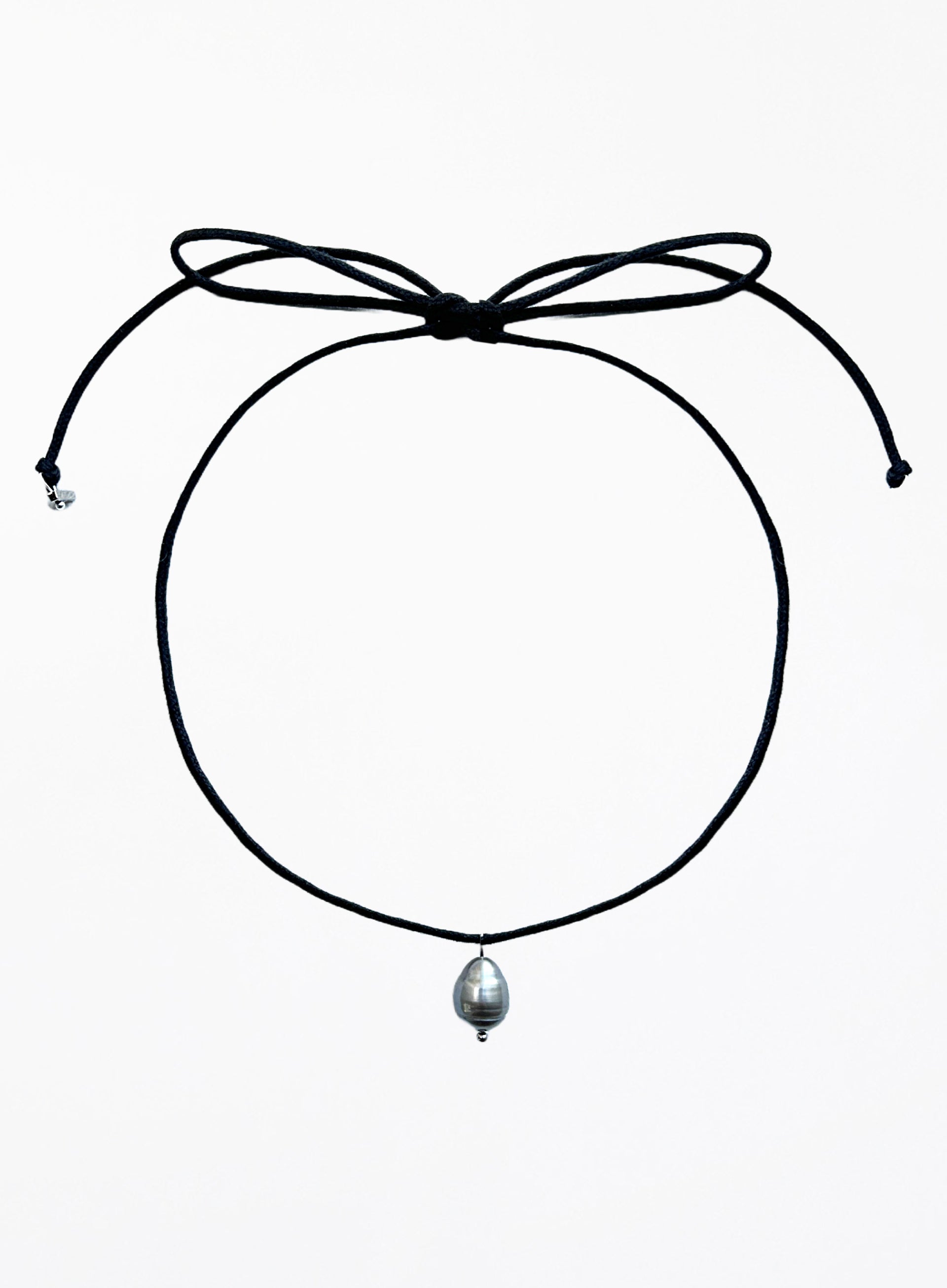 Thin black choker necklace with a pearl pendant on a white background