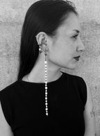 black and white photo of a woman wearing a long pearl earrings