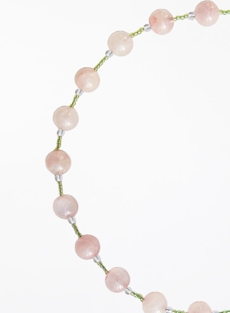 Necklace with pink and green beads beads on a white background