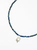 Necklace with blue beads and a white baroque pearl pendant on a white background