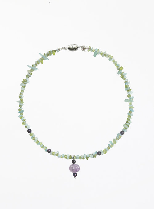 A beaded necklace made of small light green and pale blue gemstone chips, with a central pumpkin shaped lavender bead and a silver clasp, shown on a plain white background.