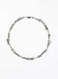 A delicate necklace made of small, irregular gray stone chips and white pearl beads, arranged in a circle on a plain white background.