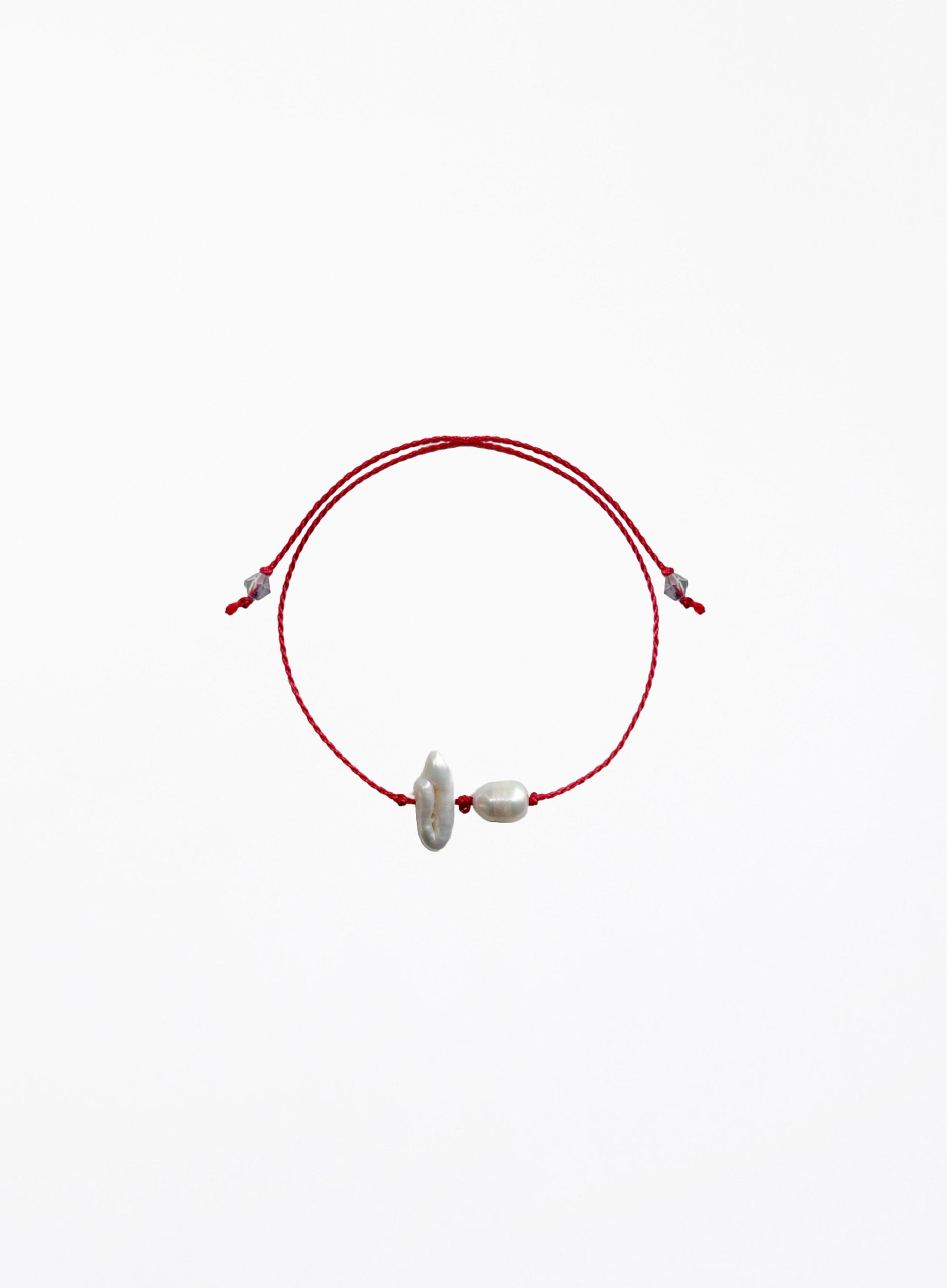 Red cord bracelet with two pearls on a white background