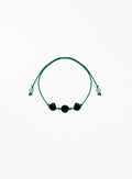 Green bracelet with black pearls on a white background