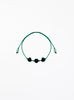 Green bracelet with black pearls on a white background