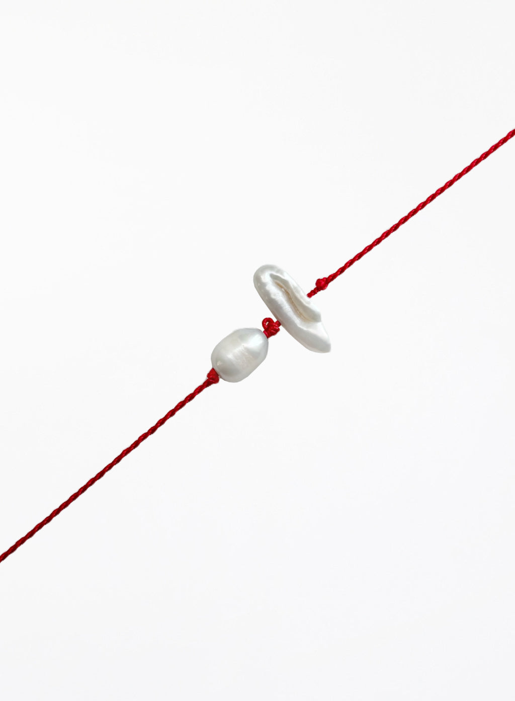 Red string with two pearls on a white background