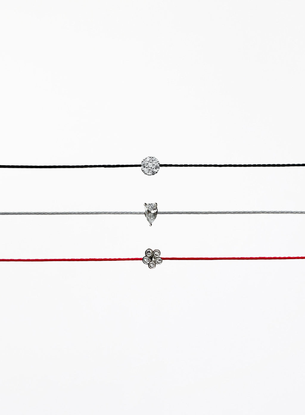 Three thin bracelets with different pendants on a white background