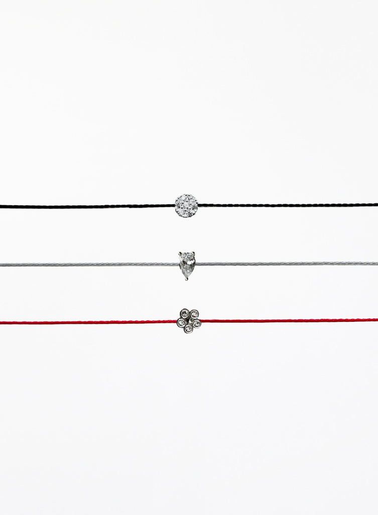 Three thin bracelets with different pendants on a white background