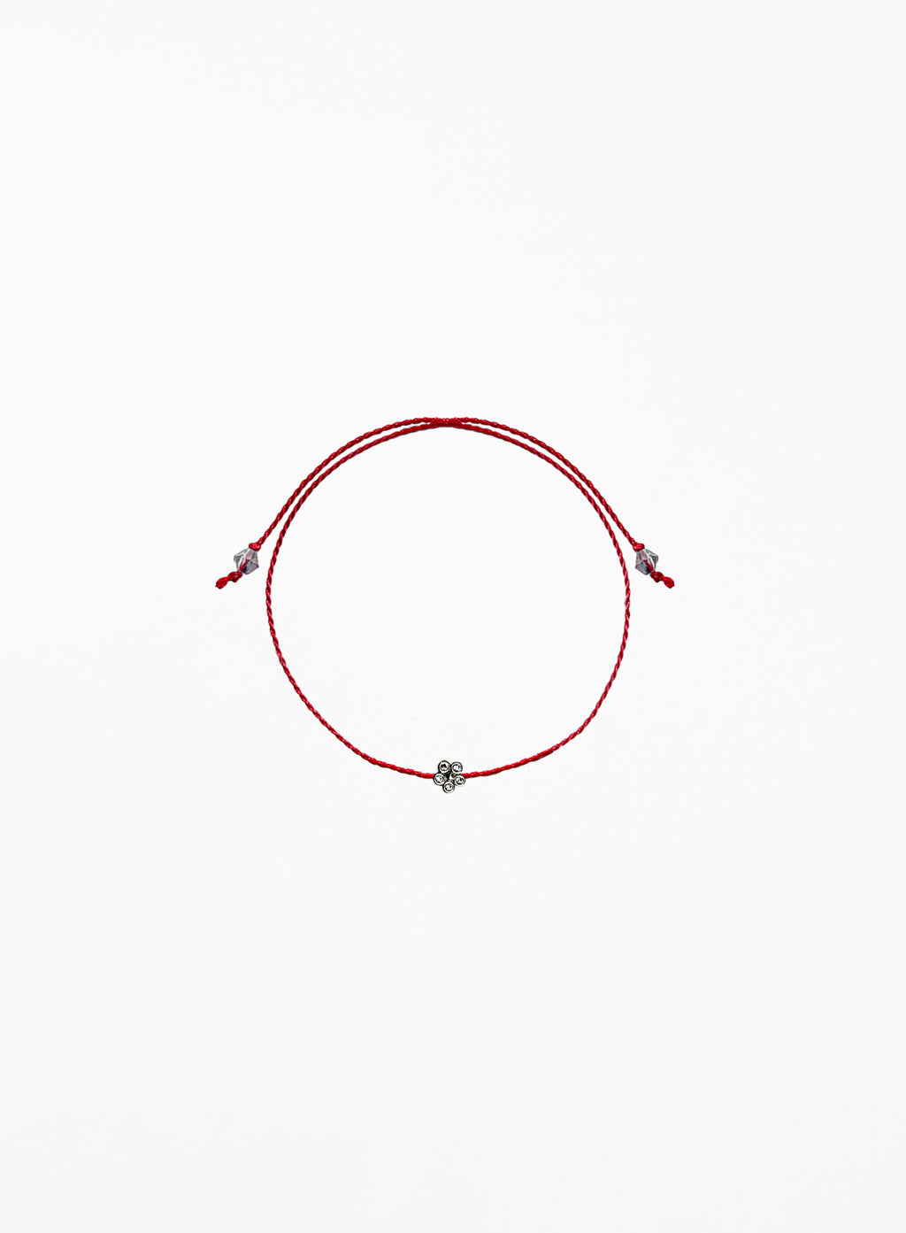 Red string bracelet with a small flower charm on a white background