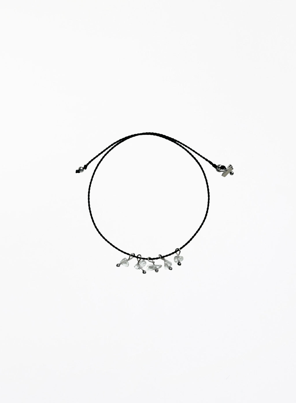 Black cord bracelet with small clear quartz charms on a white background