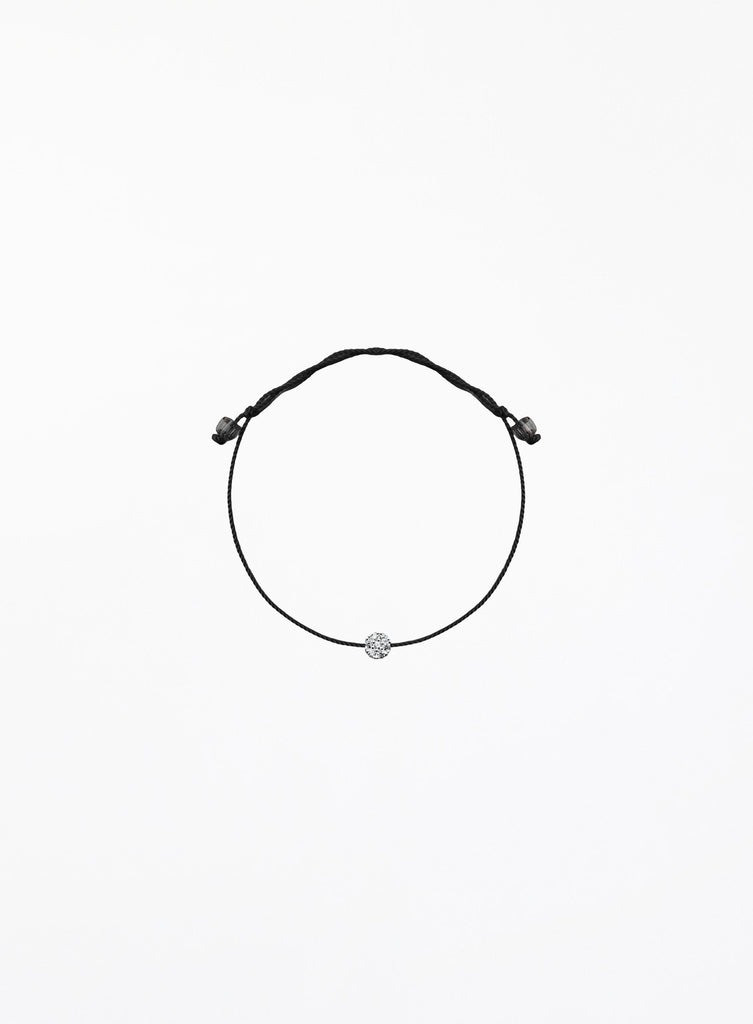 Black bracelet with a small round charm on a white background