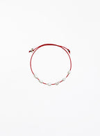 Red bracelet with pearls on a white background