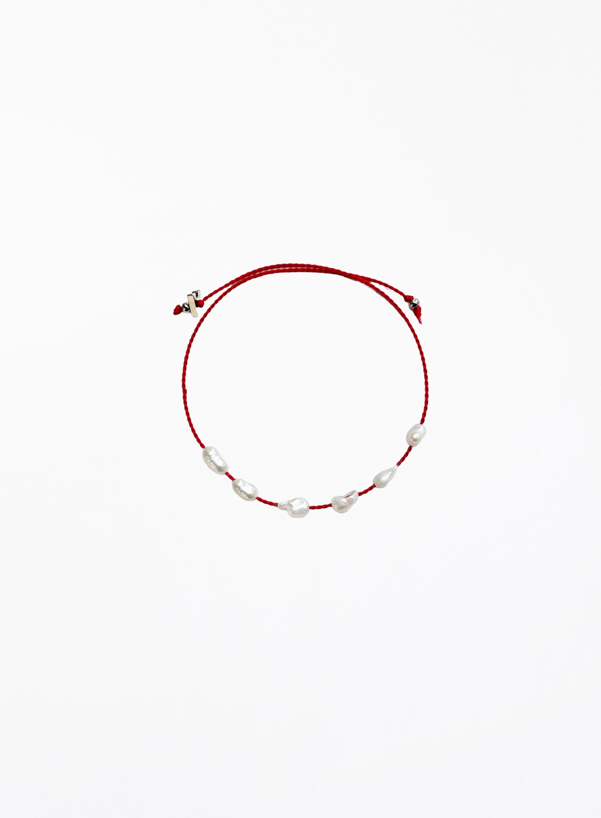 Red bracelet with pearls on a white background