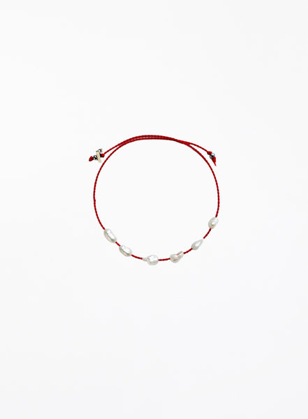 Red bracelet with pearls on a white background